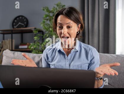 Bonne femme regardant l'écran d'ordinateur avec la bouche ouverte Banque D'Images