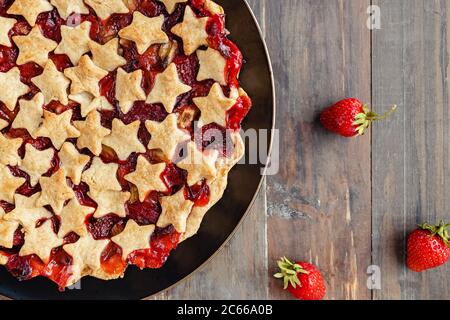 Tarte aux fraises et au rhubarbe décorée d'étoiles sur une table blanche, vue sur le dessus Banque D'Images