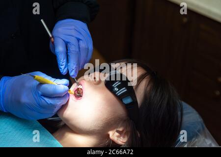 Une jeune fille est au cabinet du dentiste pour faire nettoyer ses dents. Banque D'Images