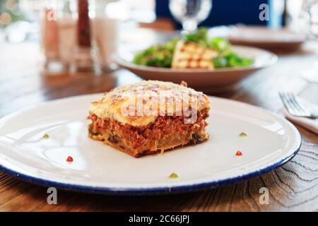 Moussaka et féta frite, cuisine grecque traditionnelle, sur table, tonifiée Banque D'Images