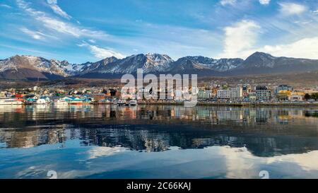 Ville d'Ushuaia et montagnes se reflétant sur les eaux du canal de Beagle, Argentine Banque D'Images