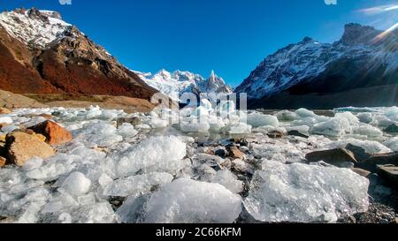Des glaces se trouvent dans la Laguna Cerro Torre, entourée de montagnes enneigées en Argentine Banque D'Images