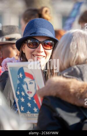 Femme souriante d'âge moyen, portant un chapeau et des lunettes de soleil, lors de la marche des femmes à Londres, le 2017 janvier Banque D'Images