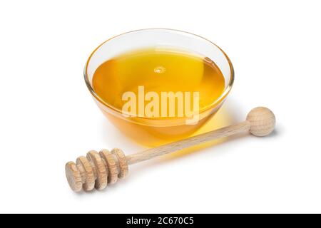 Bol en verre avec miel et un balancier en bois isolé sur fond blanc Banque D'Images