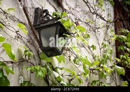 Ancienne lanterne accrochée à un mur en pierre. Une lampe rétro ancienne est suspendue à l'extérieur de la maison. Grunge le papier peint de meuble de source lumineuse cassé avec l'espace de copie. Scène W Banque D'Images