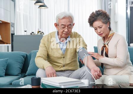 Le couple âgé mesurant la tension artérielle Banque D'Images