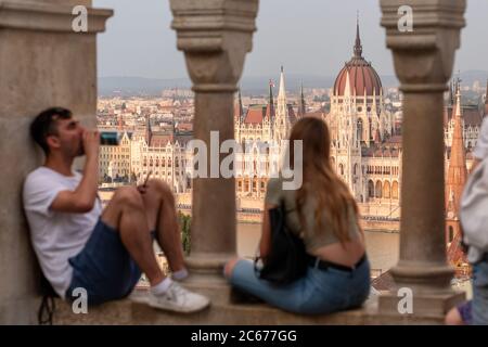 Des personnes non identifiées bénéficiant de la vue sur le Parlement hongrois depuis le bastion des pêcheurs de Budapest, Hongrie. Banque D'Images