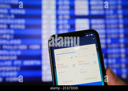 Viersen, Allemagne - juillet 6. 2020: Gros plan sur le téléphone mobile avec l'application de réservation de vols American Airlines. Arrière-plan flou du tableau de départ. (Concentrez-vous sur boo Banque D'Images