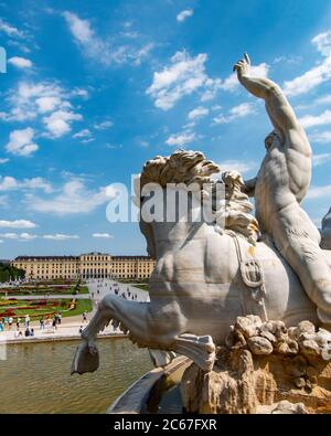 Un mériston musclé se trouve à cheval dans la fontaine de Neptune, sur le terrain du château de Schönbrunn Banque D'Images
