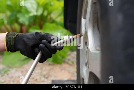 Femme changeant de pneu de voiture. Vue rapprochée. Banque D'Images