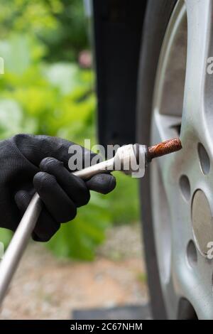 Femme changeant de pneu de voiture. Vue rapprochée. Banque D'Images