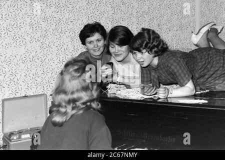 quatre jeunes femmes au piano enregistrant de la musique et chantant en utilisant le rouleau à bobine magnétophone années 1960 hongrie Banque D'Images