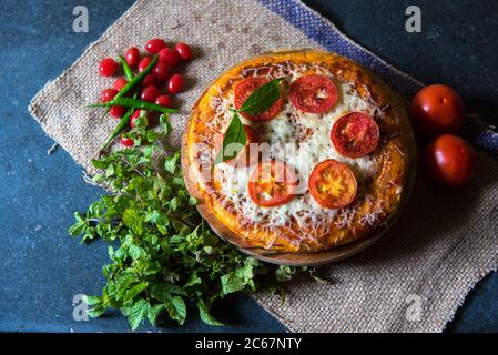 Pizza avec feuilles de menthe et cerises en arrangement sur un fond avec l'utilisation de l'accent sélectif sur un ingrédient particulier Banque D'Images