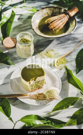 Cheesecake vert au matcha et feuilles sur fond de table en marbre Banque D'Images