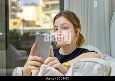 Adolescente prenant un selfie avec le visage de canard à la maison Banque D'Images