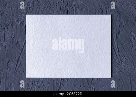 carte papier texturée blanche sur fond gris foncé uni Banque D'Images