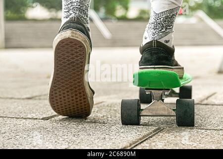 Gros plan de jambes de type en short sur un sou extérieur de skateboard.concept d'activité de loisirs, sport, extrême, passe-temps et mouvement. Banque D'Images