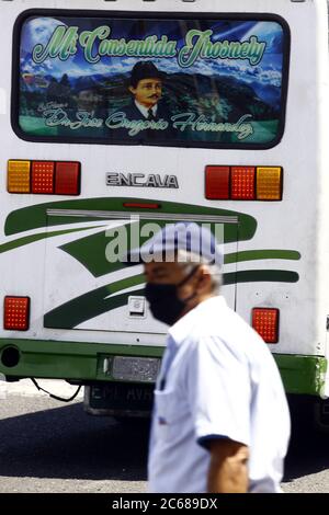 Valence, Carabobo, Venezuela. 6 juillet 2020. 06 juillet 2020. Un homme, portant un masque facial, marche devant une affiche du béni vénézuélien José Gregorio Hernandez, qui est considéré par les croyants, comme le médecin des pauvres, est attribué un miracle médical, reconnu par le Vatican. Photo: Juan Carlos Hernandez. Crédit: Juan Carlos Hernandez/ZUMA Wire/Alay Live News Banque D'Images