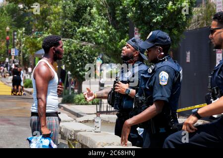 Un manifestant interroge un policier de la ville de Black Lives Matter Plaza sur la façon dont il change de police, obtient une réponse impolie, Washington, DC, USA Banque D'Images