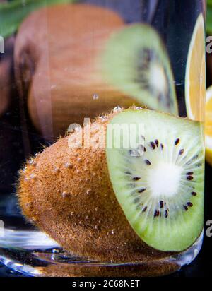 Gros plan d'une tranche de kiwi qui a été placée dans un verre d'eau Banque D'Images