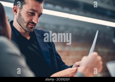 Deux collègues coopérant dans le bureau tenant le document en main Banque D'Images