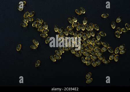 Capsules de gel de vitamine d ou d'oméga 3 sur fond noir. Groupe de vitamines gros plan. Banque D'Images