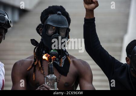 de jeunes hommes africanamericains agressifs ont mis le feu sur des bouteilles dans les rues pendant la manifestation après avoir tué un homme à peau noire par la police Banque D'Images