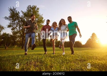 Groupe de jeunes amis hippster s'amusant et dansant en campagne. Les hommes et les femmes ayant de grands moments ensemble à l'extérieur Banque D'Images