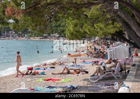 Début de la saison estivale en Croatie. Plage publique populaire à Makarska. Plage surpeuplée comme d'habitude, même en période d'épidémie de covid, les gens sont toujours Banque D'Images