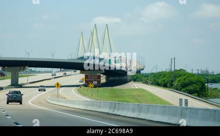 Sur une autoroute avec une jonction importante et un grand pont de suspension de câble au loin Banque D'Images