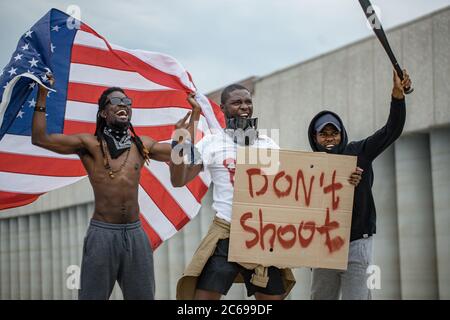 Les manifestations contre la vie noire sont chose importante. Trois personnes afroamericaines avec des affiches dans la rue, des personnes noires insatisfaites de l'injustice policière et de la gairete Banque D'Images