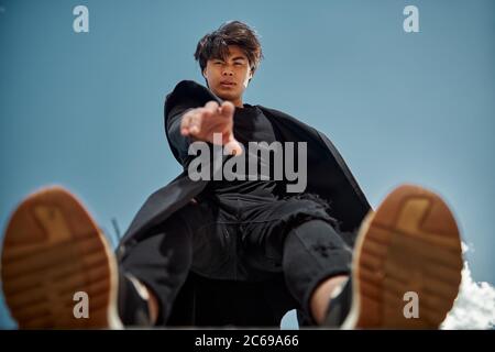 Beau jeune homme debout sous le ciel bleu Banque D'Images