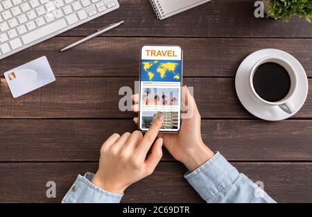 Femme méconnue qui naviguant dans l'application de voyage sur un smartphone dans Office, gérant sa réservation Banque D'Images