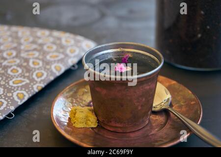 De l'eau de rose aux graines de chia et de vrais pétales de rose servi dans des tasses de cuivre comme boisson de bienvenue dans un restaurant à Shiraz, en Iran. Banque D'Images