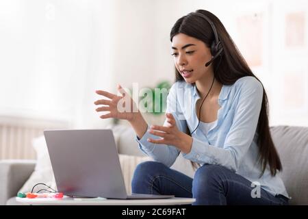 Tutorat en ligne. Jeune femme asiatique ayant un appel vidéo avec des étudiants Banque D'Images