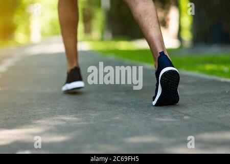 Jogging inreconnaissable dans les chaussures de sport qui s'exécute au parc le matin, gros plan Banque D'Images