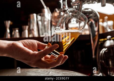 Bière artisanale au bar. Barman verse une boisson du robinet dans le verre Banque D'Images