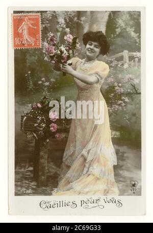 Début 1900, la carte postale française de voeux sentimentale teinté d'une jolie femme en robe longue coulant souriant et cueillant des roses - intitulé 'cueilli pour vous', France, vers 1911 Banque D'Images