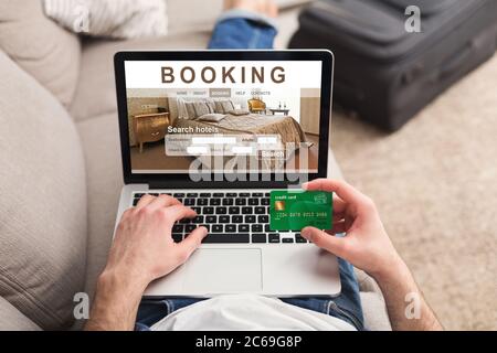 Mains de l'homme voyageur réservant l'hôtel pour les vacances Banque D'Images