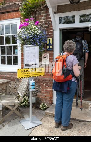 Les pubs ont rouvert en Angleterre après que les restrictions du coronavirus Covid-19 aient été assouplies, le 7 juillet 2020, au Royaume-Uni. Pub avec station de lavage des mains et panneaux de sécurité à l'extérieur Banque D'Images