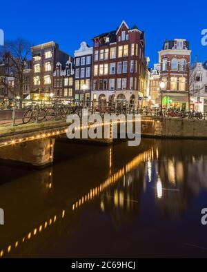 AMSTERDAM, PAYS-BAS - 16 FÉVRIER 2016 : vue nocturne sur le canal Keizersgracht d'Amsterdam. Des bâtiments, des ponts et des vélos sont visibles. Banque D'Images