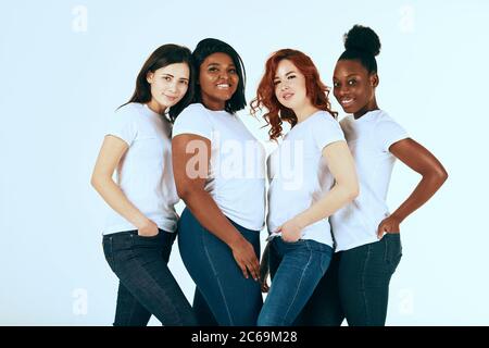 amitié, mode, corps positif, diverse femme concept de beauté - groupe de heureux multiculturel différentes tailles femmes dans l'habillement décontracté posant sur blanc b Banque D'Images