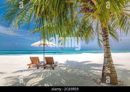 Romantique plage destination lune de miel pour les couples, chaises de plage avec feuilles de palmier et parasol, à proximité de la mer bleue. Vue magnifique sur les vacances d'été Banque D'Images