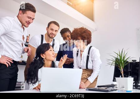 Groupe multiethnique réuni pour examiner le projet d'ordinateur portable, partager le point de vue Banque D'Images