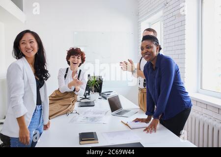 Une équipe multiethnique de personnes heureuses applaudissant à la conférence internationale après une solution réussie Banque D'Images