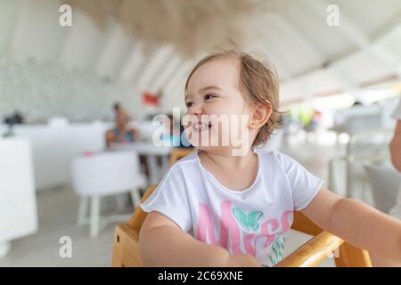 Adorable petite fille mangeant des légumes sains et des pommes de terre frites malsaines. Mignon bébé heureux enfant prenant la nourriture de plat à la garderie ou à la garderie Banque D'Images