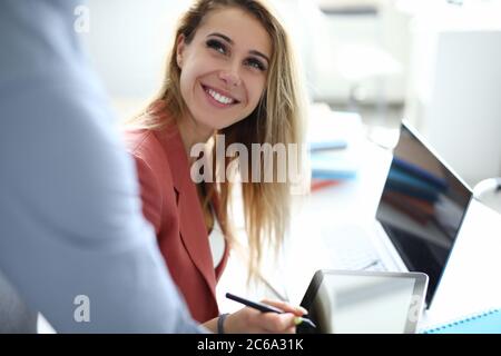 Une femme d'affaires au bureau met une signature électronique sur une tablette Banque D'Images