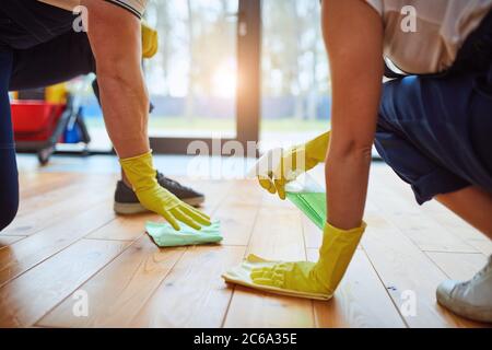 nettoyage régulier. Nettoyage des gens, des concierges lavant le sol avec des chiffons et du spray. Concept d'entretien ménager. Arrière-plan de la fenêtre Banque D'Images