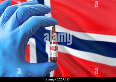 Drapeau des îles Bouvet avec le concept Covid-19 du coronavirus. Médecin avec des gants médicaux de protection bleus tenant une bouteille de vaccin. Virus épidémique, COV-19, Co Banque D'Images