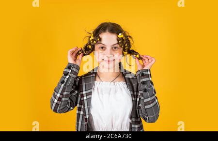 Conseils pour la coiffure des enfants. Outils de coiffure et accessoires de coiffure. Enfant avec des patches sur le visage. Posez avec des pillards. Bonne fille dans des pillards jouant au salon de coiffure. Bonne pour les cheveux Banque D'Images